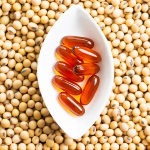 A bowl of lecithin capsules on a pile of soybeans